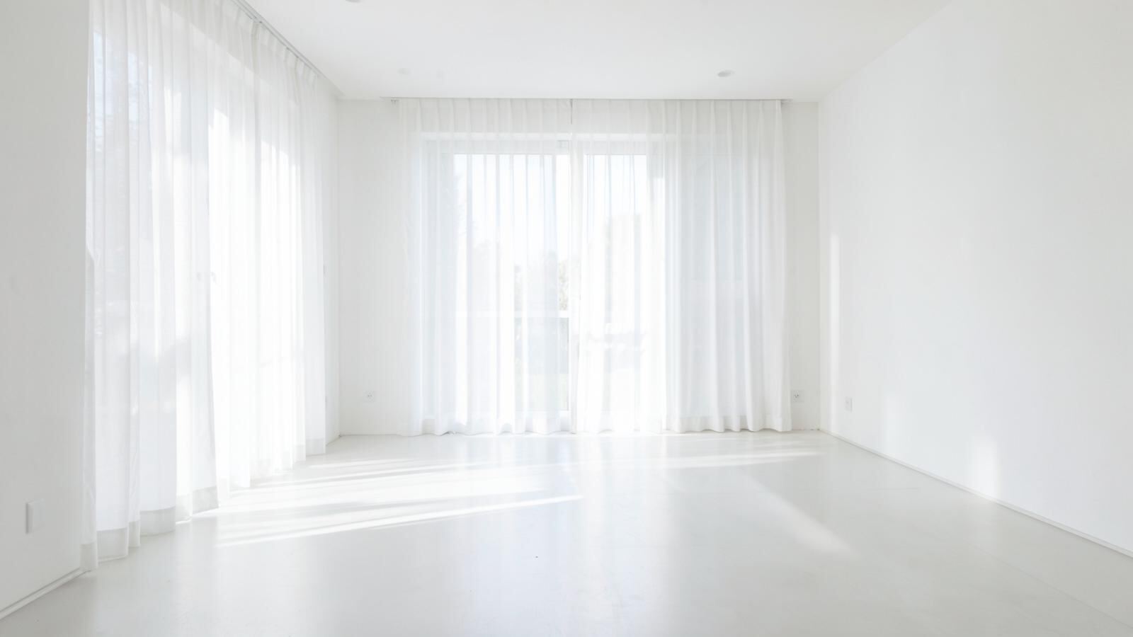 Bright, spotless living room with sheer curtains and sunlight