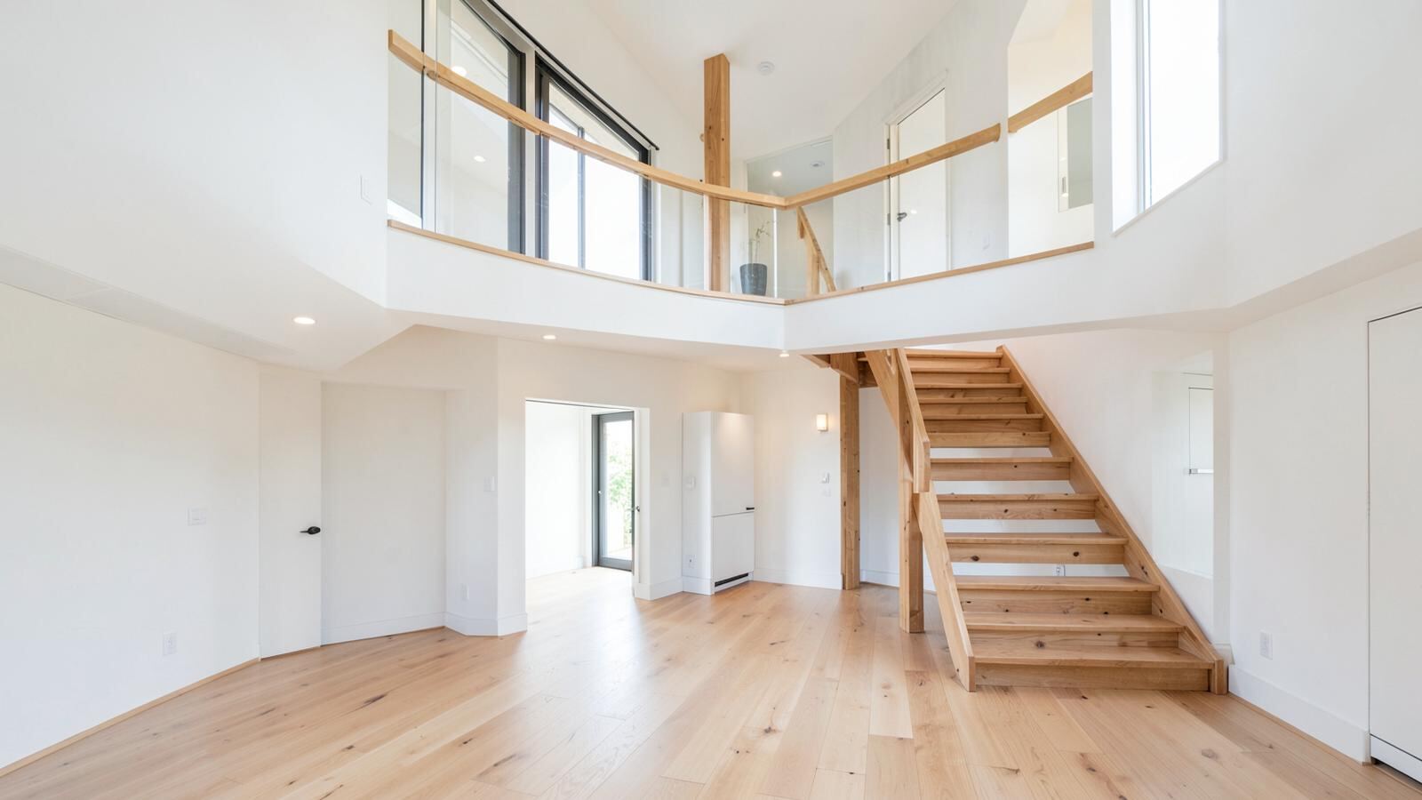 Two-storey home interior with a wooden staircase and upper landing