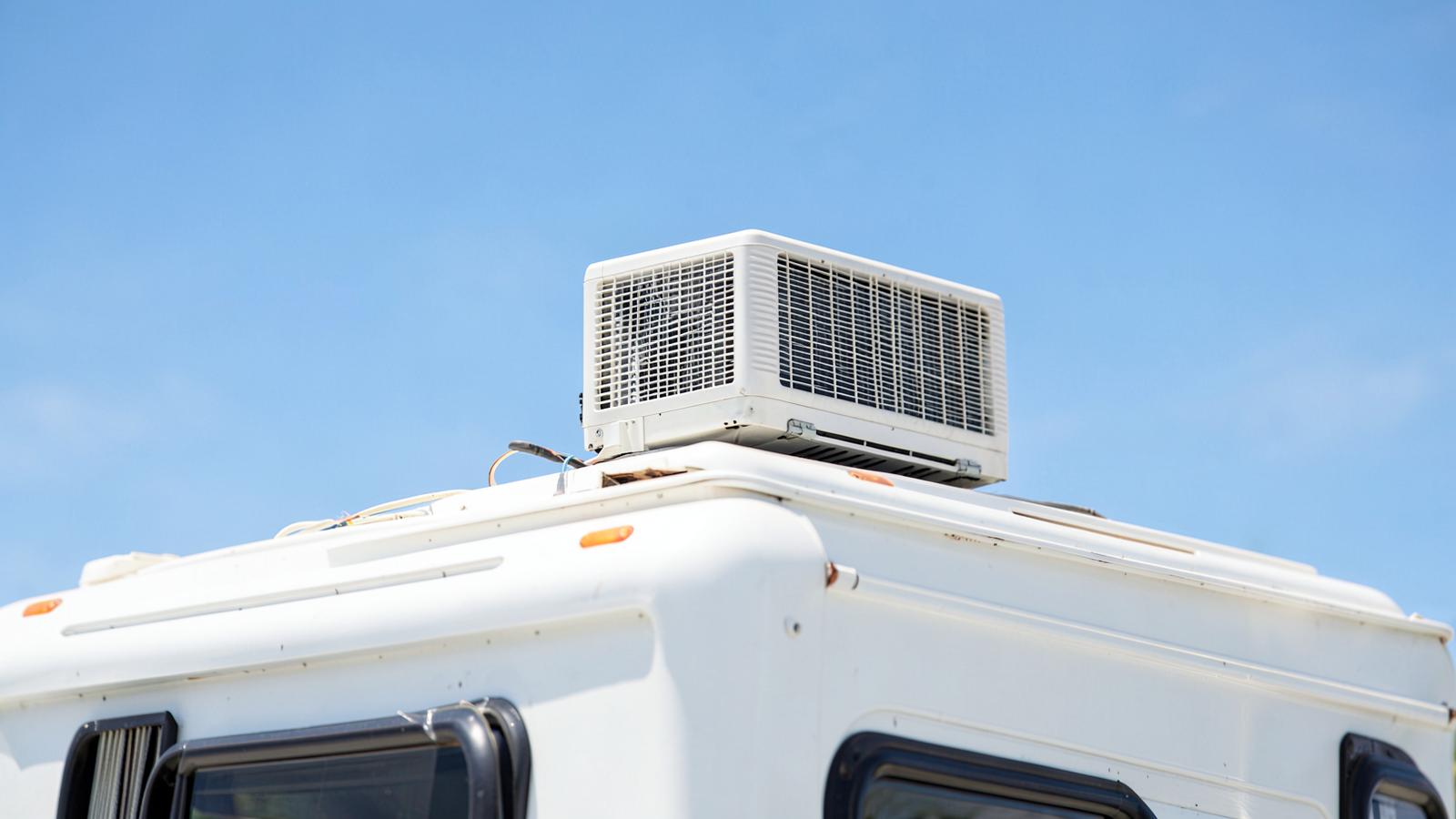 Rooftop air conditioner unit on a white RV against a bright summer sky