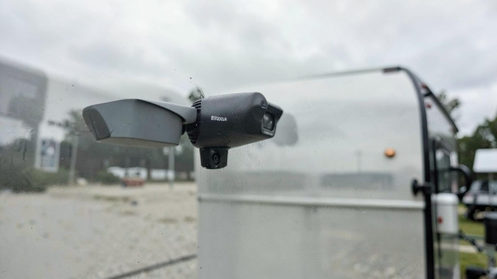 Small backup camera mounted high on the rear wall of a travel trailer