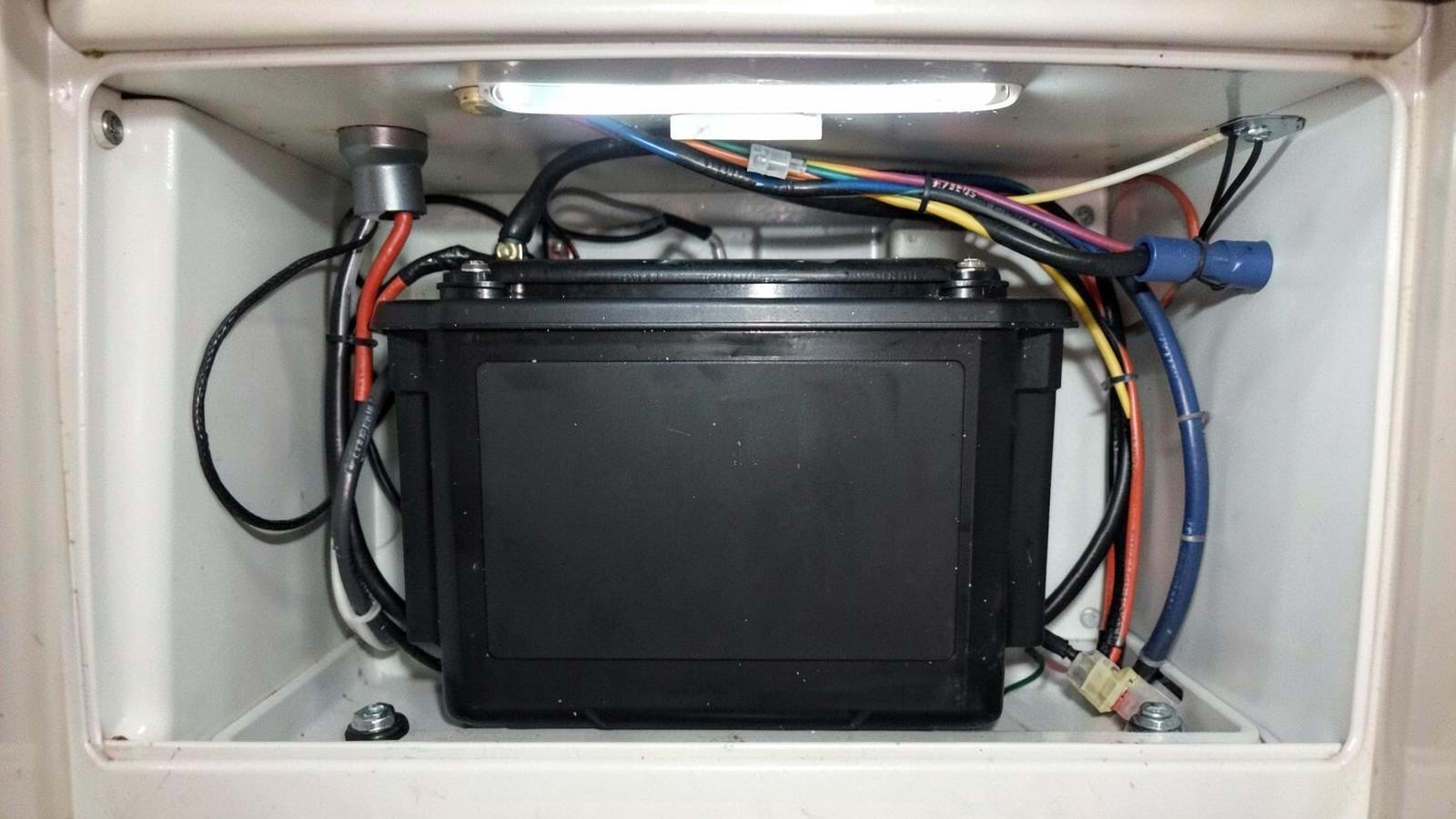 Lithium house battery installed in a tidy RV battery compartment with neat cabling