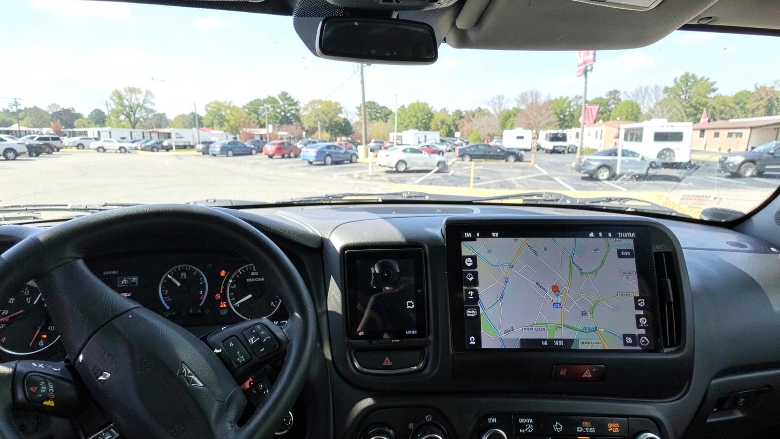 RV dashboard with a small camera monitor beside a larger navigation screen